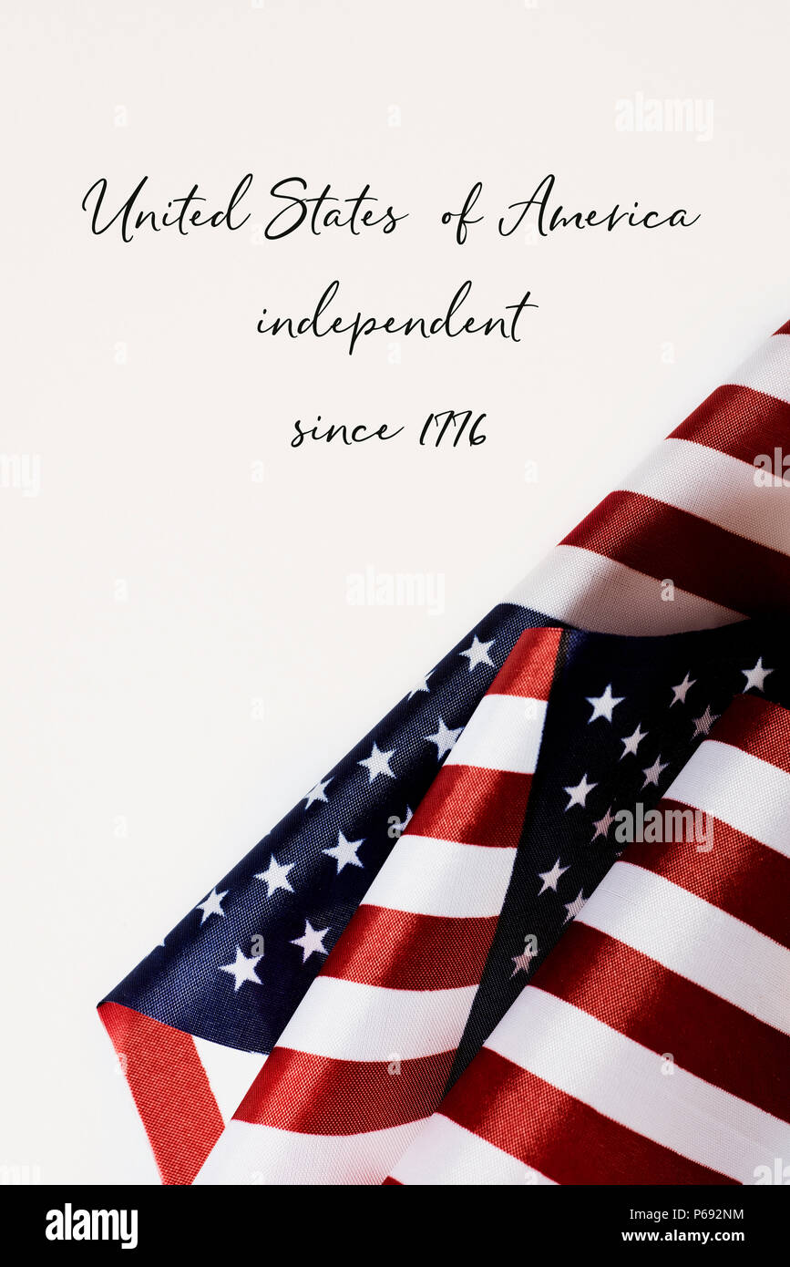 some american flags and the text united states of america independent since 1776 against an off-white background Stock Photo