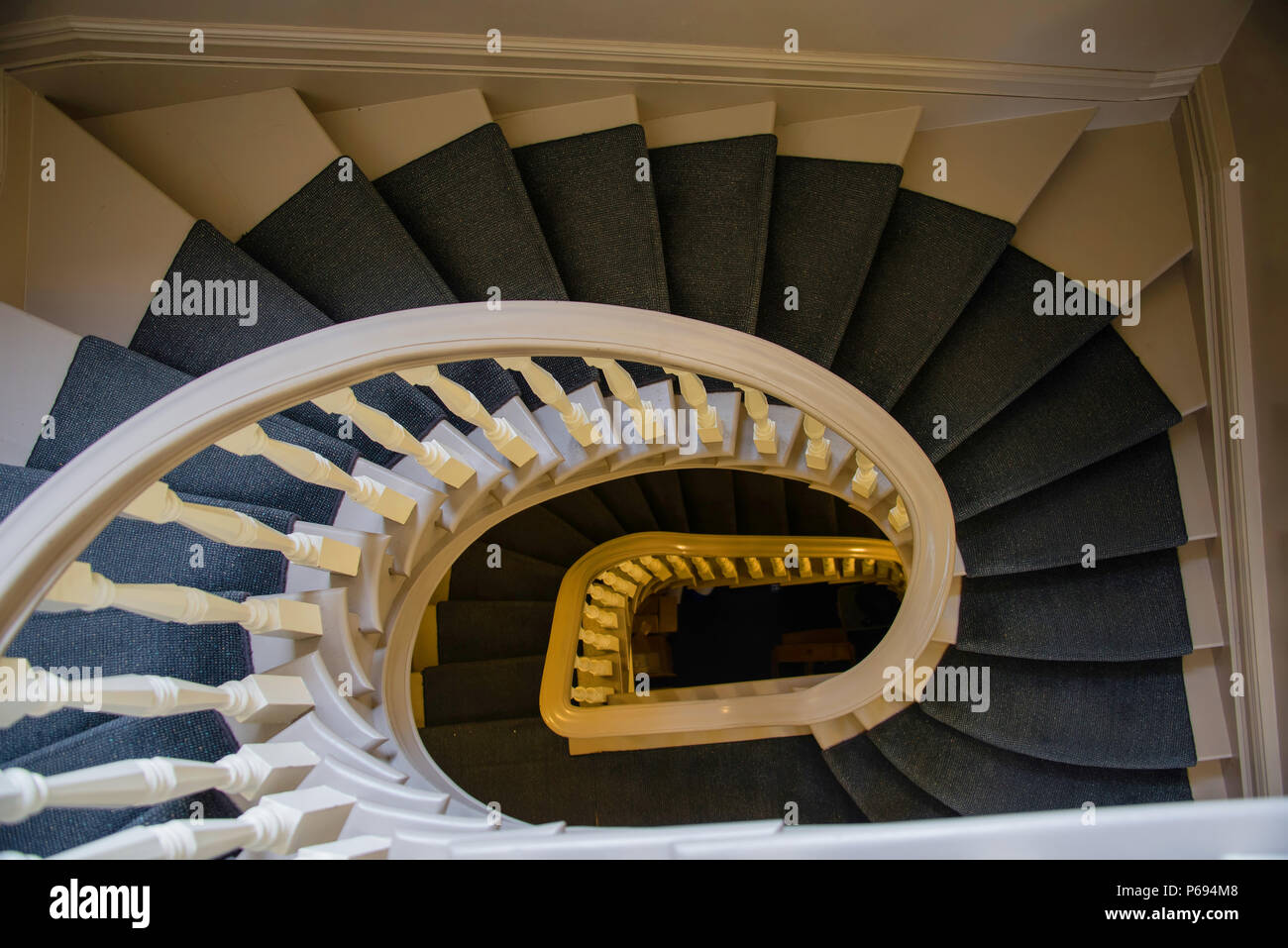 Reconditioned indoor staircase with balustrades and pale decor Stock Photo