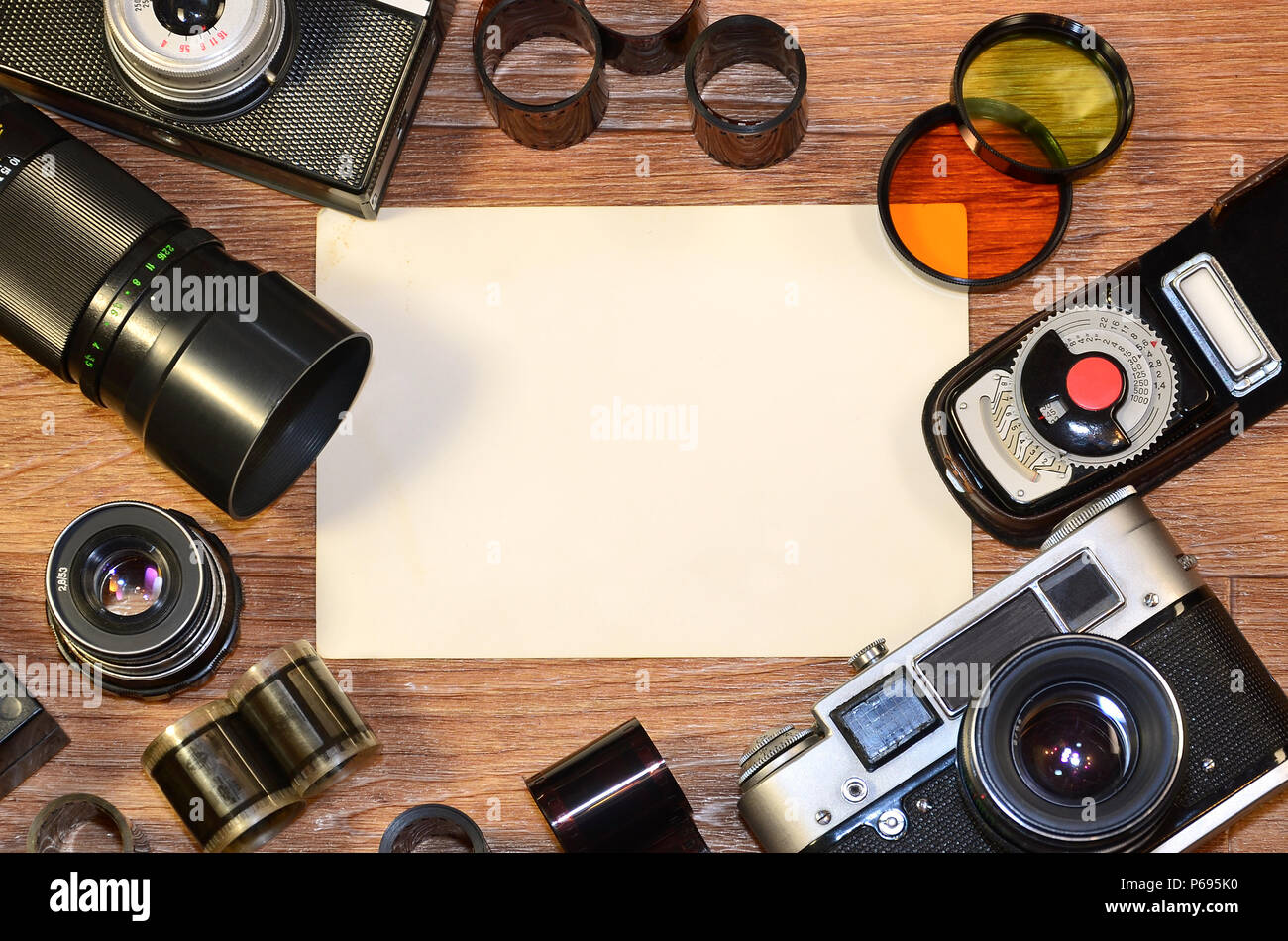 Retro camera and some old photos on wooden table. Vintage mock up for artwork or logo design