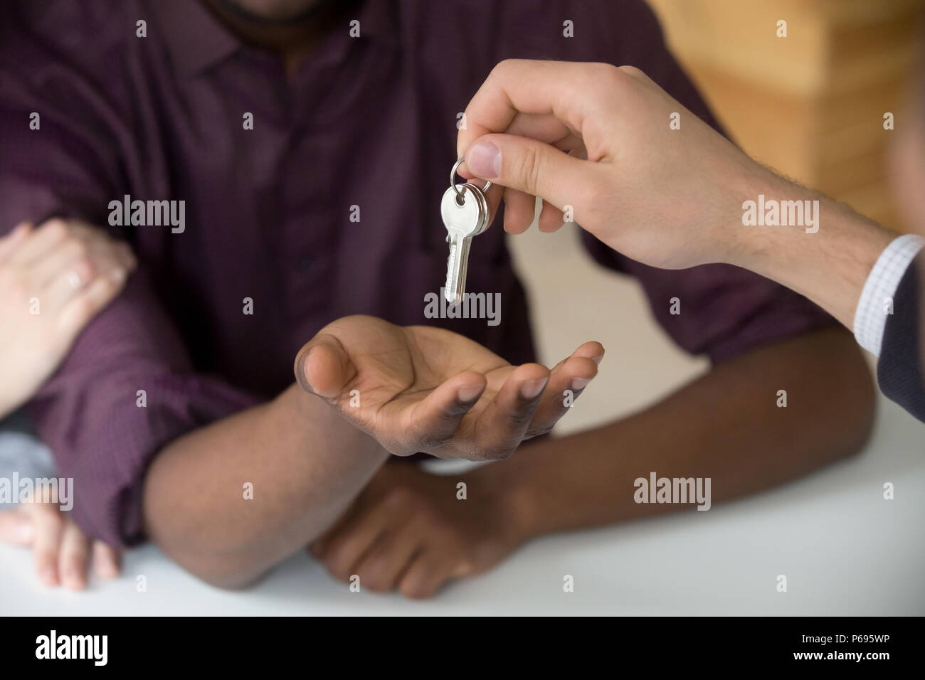 Realtor giving keys to black husband buying home with girlfriend Stock Photo