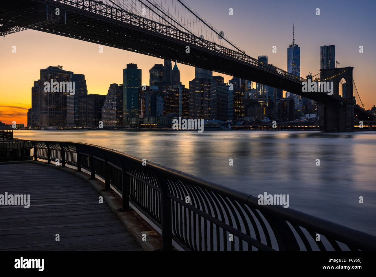 Lower Manhattan skyscrapers and the Brooklyn Bridge at sunset from