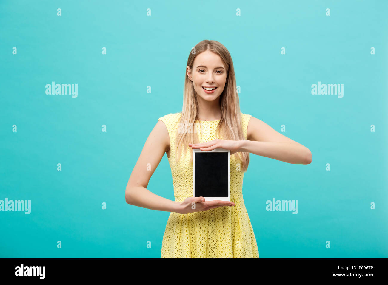 Pretty smiling woman showing blank black screen of digital tablet ...