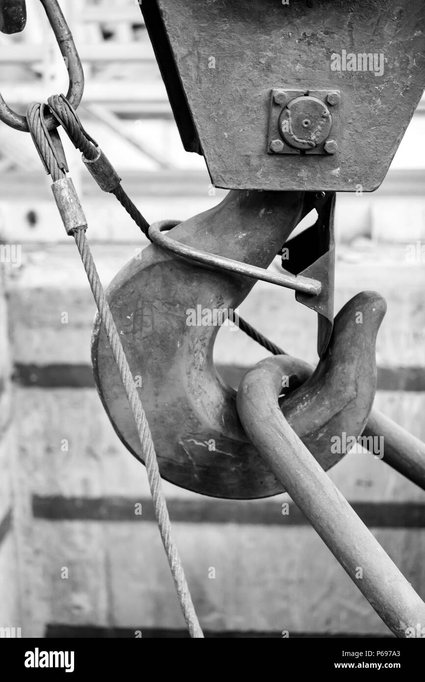 large iron hook used to lift heavy loads in a workshop with safety latch Stock Photo