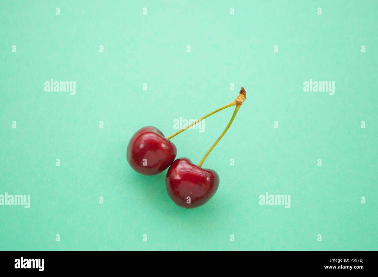 Turquoise Berry Two sweet cherry berry on turquoise background Stock Photo - Alamy