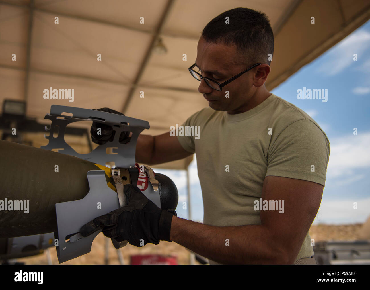 Staff Sgt. Alejandro Medina, 455th Expeditionary Maintenance Squadron Munitions Flight munitions system specialist, helps build a GBU-54 munition at Bagram Airfield, Afghanistan, May 26, 2016. Munitions systems specialists handle, store, transport, arm and disarm weapons systems. (U.S. Air Force photo by Senior Airman Justyn M. Freeman) Stock Photo