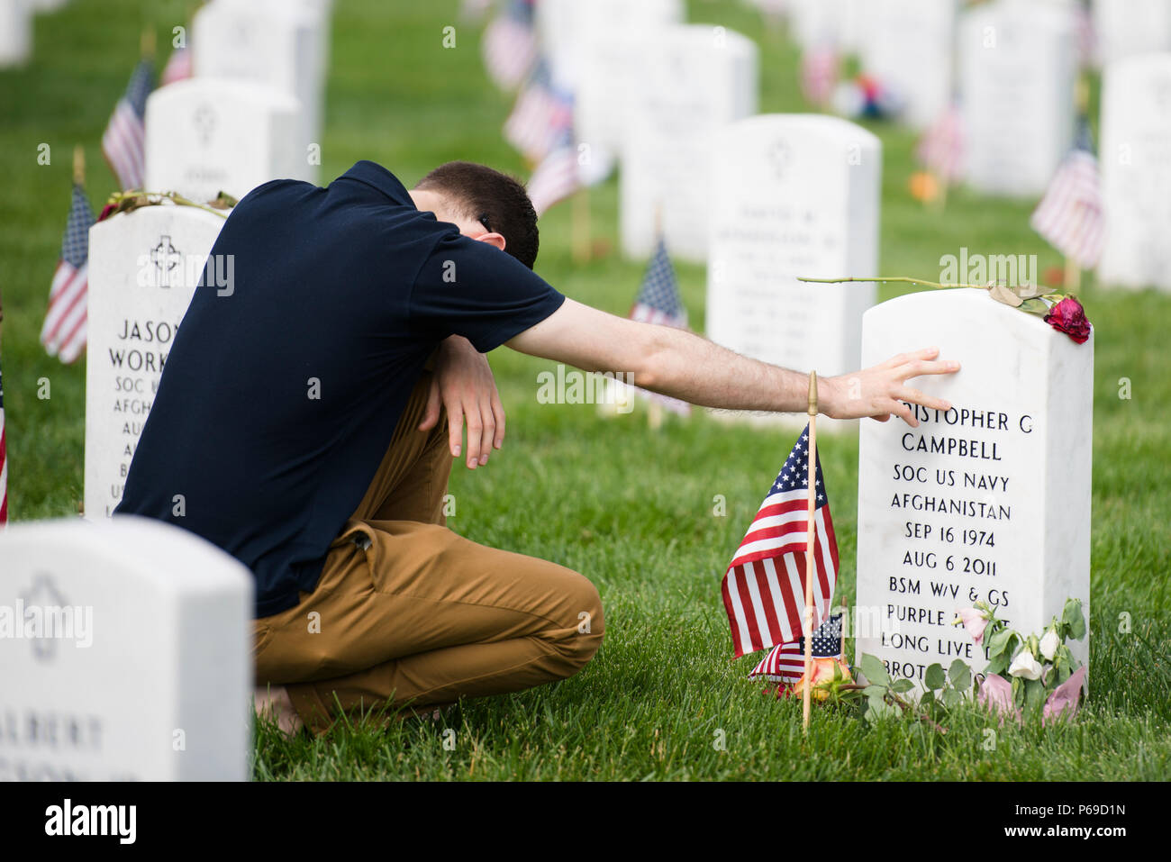 Austin Williams visits the gravesite of U.S. Navy Petty Officer 1st Class Christopher C. Campbell in Section 60 of Arlington National Cemetery on Memorial Day, May 30, 2016. Campbell was one of 30 Americans killed when a CH-47 Chinook helicopter, with the call sign Extortion 17, crashed in Afghanistan. (U.S. Army photo by Rachel Larue/Arlington National Cemetery/released) Stock Photo