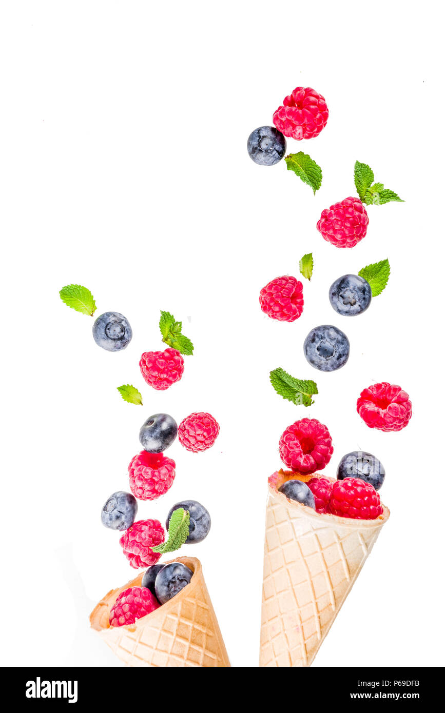 Creative layout with raspberry and blueberry with waffle ice cream cones, simple pattern above copy space Stock Photo