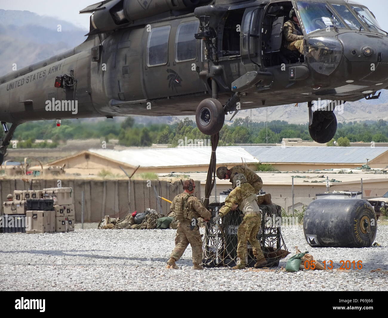 A UH-60 Black Hawk helicopter sling loads equipment from Forward Operating Base Joyce, Afghanistan, May 13, 2016. The 40th CAB sent a team of Washington and California Army National Guard fuelers to eastern Afghanistan to support the Afghan aviation mission. (Photo courtesy of Spc. Jeremy Miller) Stock Photo