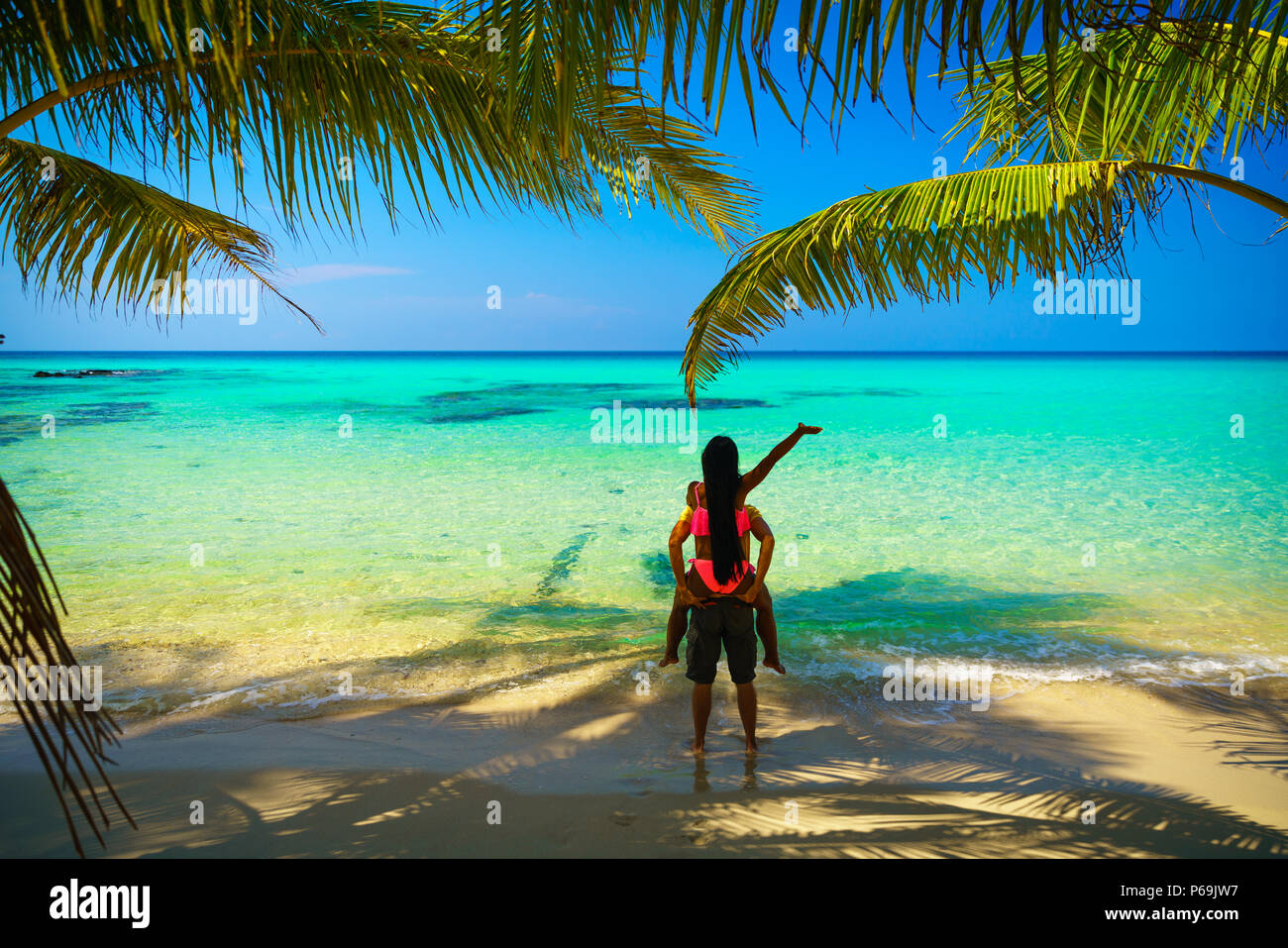A Guy Carrying A Girl On His Back At The Beach Outdoors