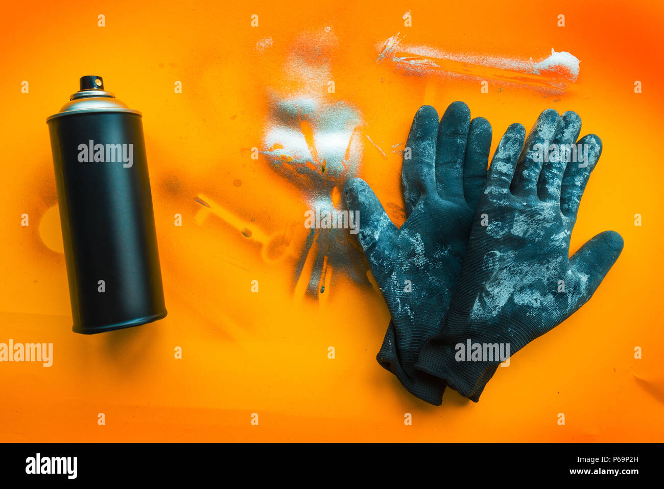 Black color spray can and gloves for graffiti artwork on grunge yellow background Stock Photo