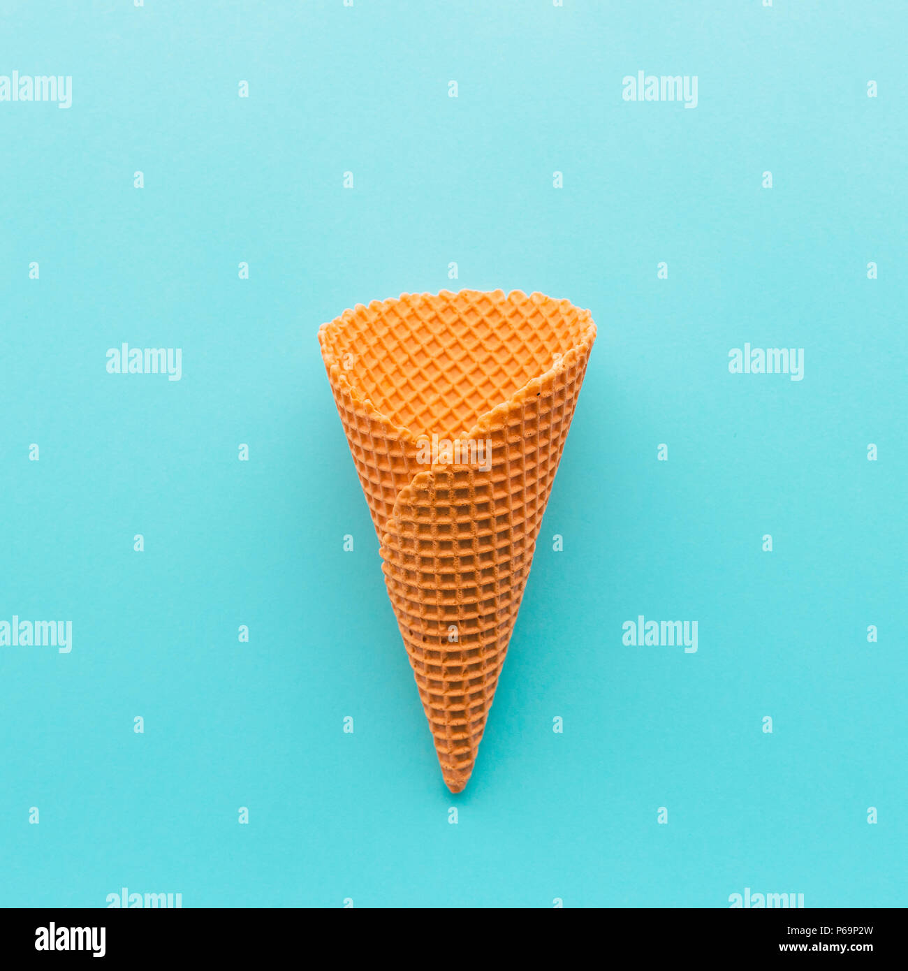 Ice cream cone from above on pastel blue, minimal flat lay composition with copy space Stock Photo