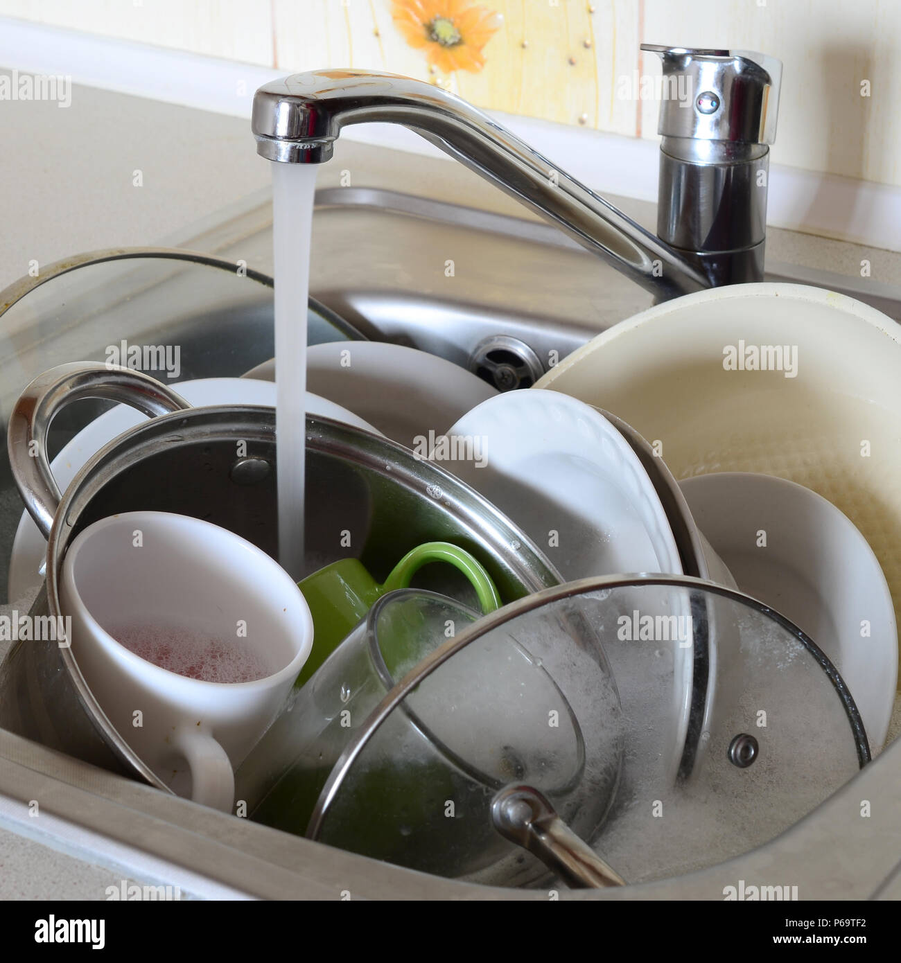 Dirty Dishes And Unwashed Kitchen Appliances Lie In Foam Water