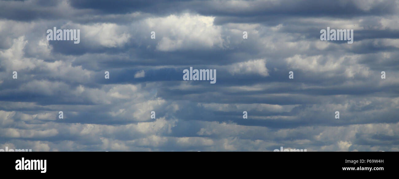 A blue sky with lots of white clouds of different sizes Stock Photo - Alamy