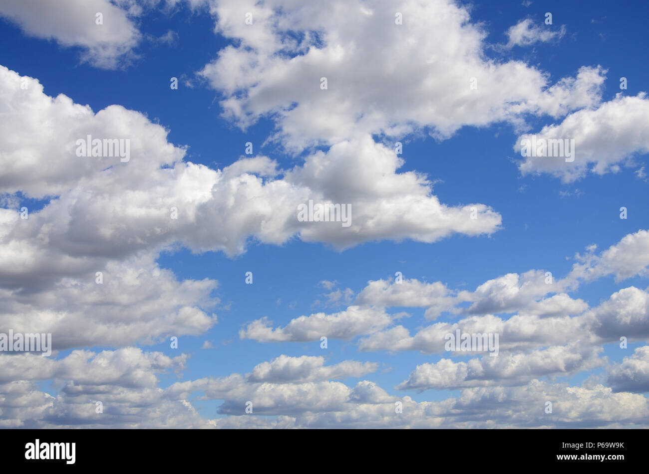 A blue sky with lots of white clouds of different sizes Stock Photo - Alamy