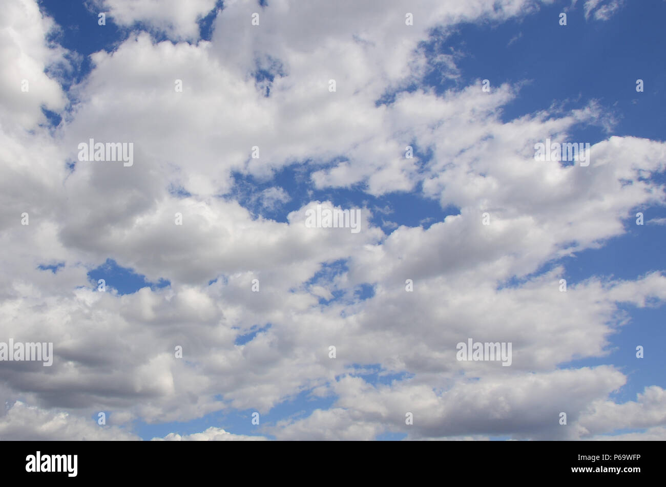 A blue sky with lots of white clouds of different sizes Stock Photo - Alamy