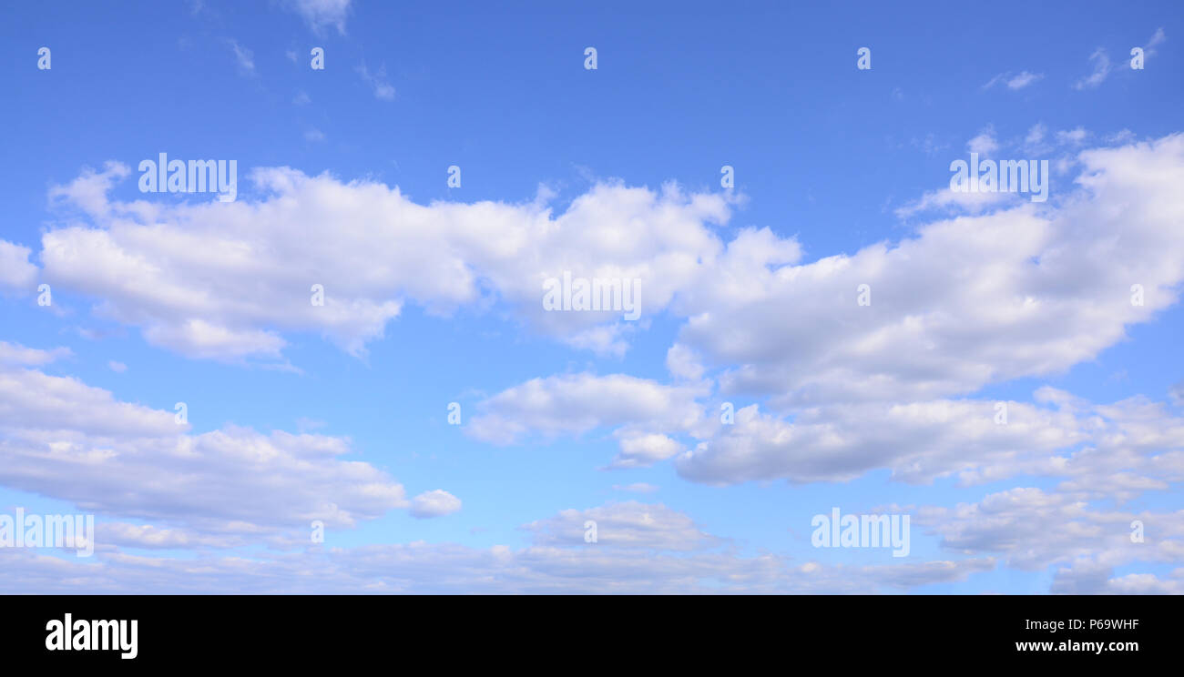 A blue sky with lots of white clouds of different sizes Stock Photo - Alamy