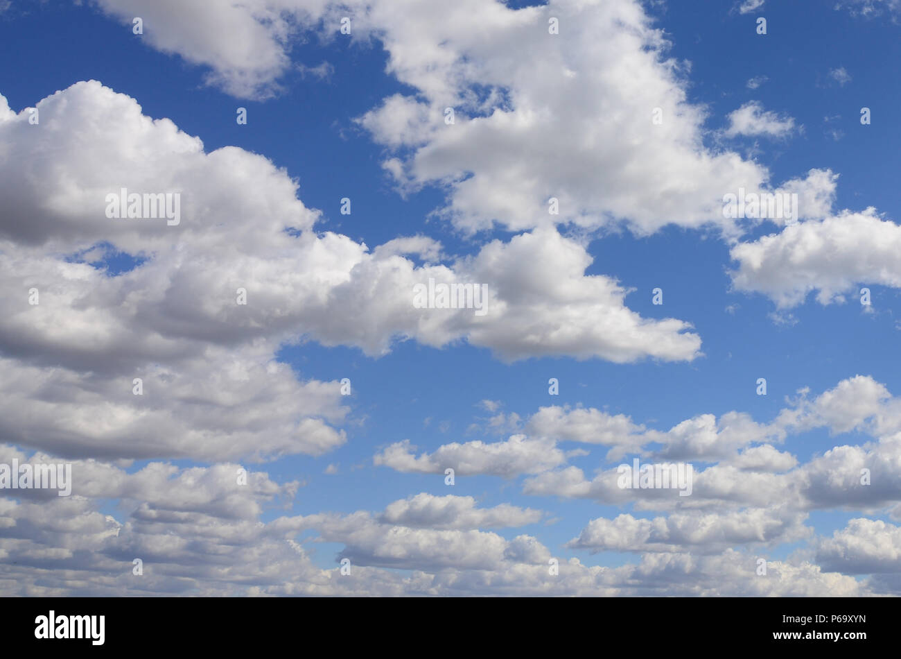 A blue sky with lots of white clouds of different sizes Stock Photo - Alamy