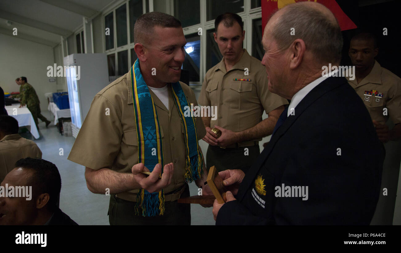Capt. Jared Dalton, the team captain of the Marine Corps Shooting Team, exchanges gifts with Warrant Officer Class One Ian Beattie, the team captain of the Australian Army Shooting Team, during the International Dinner at Puckapunyal Military Area in Victoria, Australia, May 20, 2016. The Australian Army Skill at Arms Meeting 2016 concluded May 20. During the dinner, competitors of AASAM met with each other to exchange gifts and build upon the camaraderie from the three weeks of competition. Stock Photo