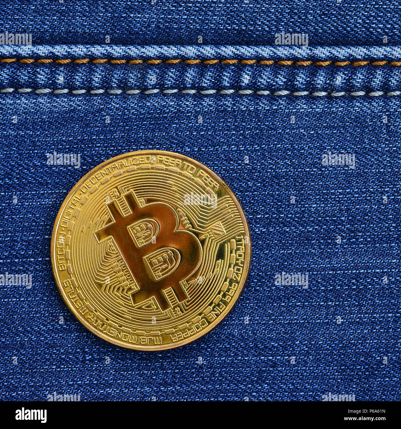Golden Bitcoin lies on a blue jeans fabric. New virtual money. New crypto  currency in the form of the coins Stock Photo - Alamy