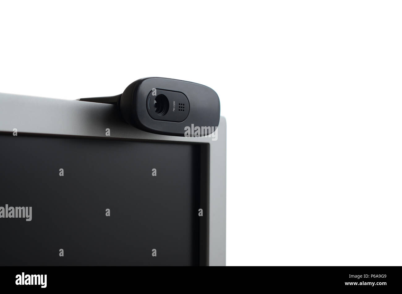 A modern web camera is installed on the body of a flat screen monitor ...