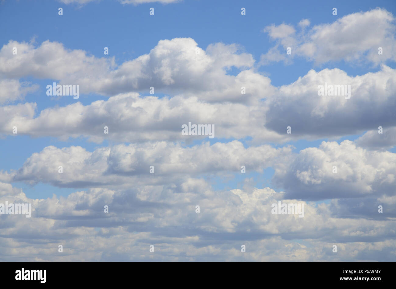 A blue sky with lots of white clouds of different sizes Stock Photo - Alamy