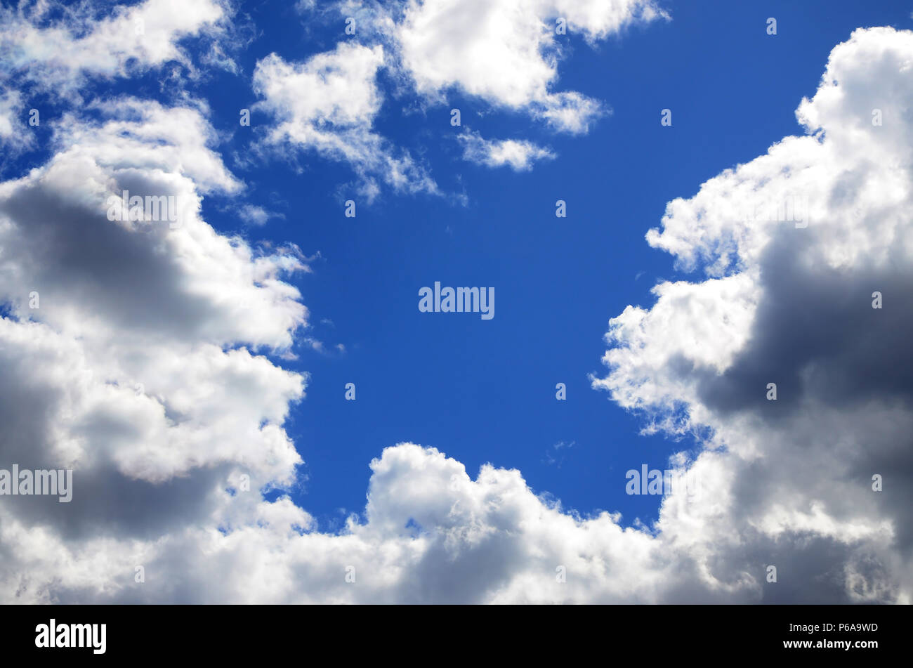The blue sky with a lot of white clouds of different sizes, forming a ...