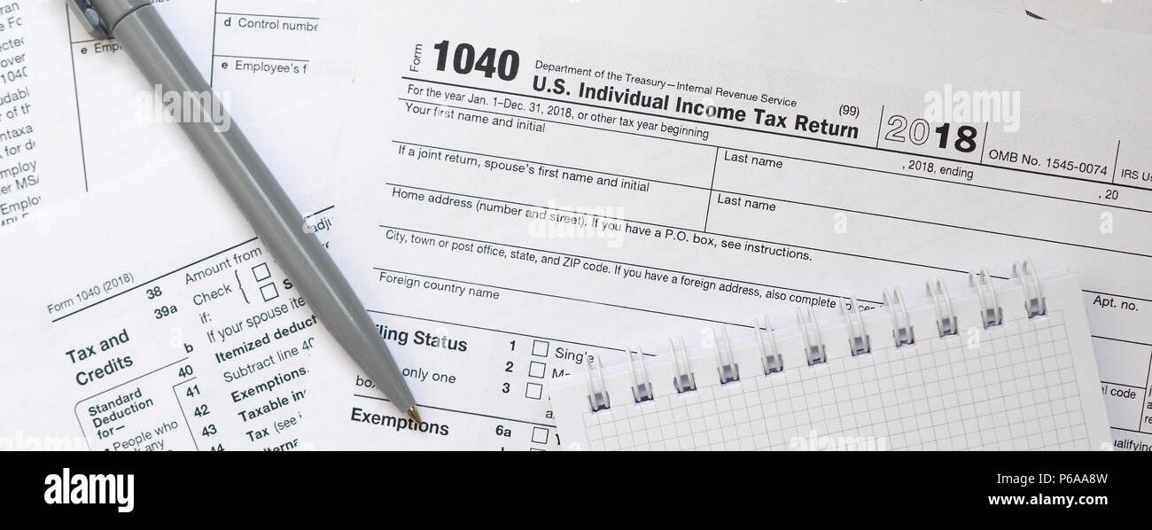 The pen and notebook is lies on the tax form 1040 U.S. Individual 