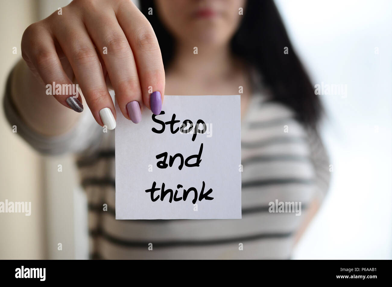 Young sad girl shows a white sticker. Caucasian brunette holding a ...
