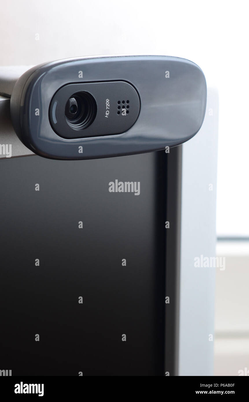 A modern web camera is installed on the body of a flat screen monitor ...