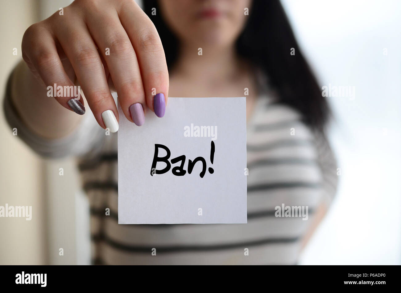 Young sad girl shows a white sticker. Caucasian brunette holding a ...