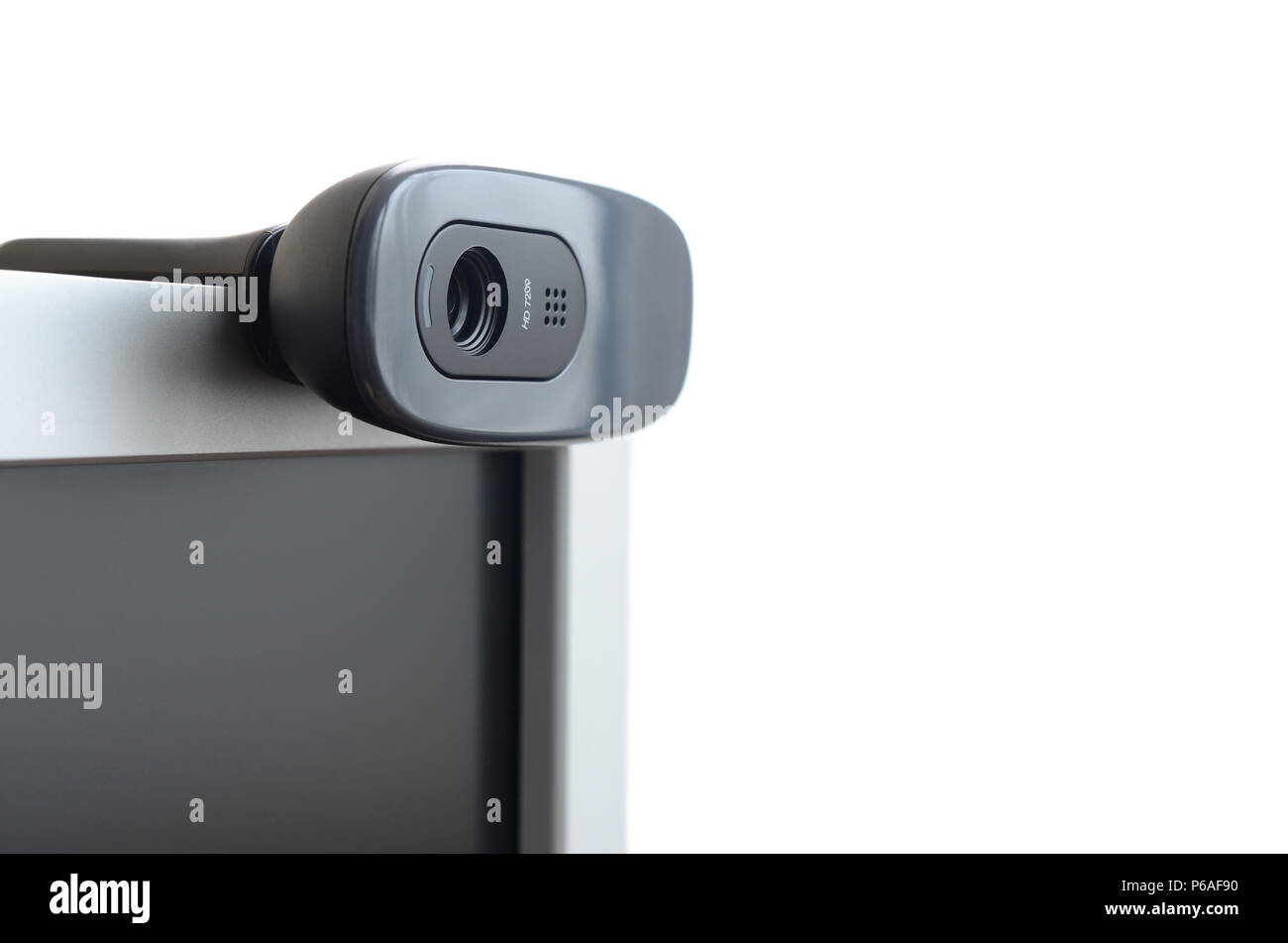 A modern web camera is installed on the body of a flat screen monitor ...