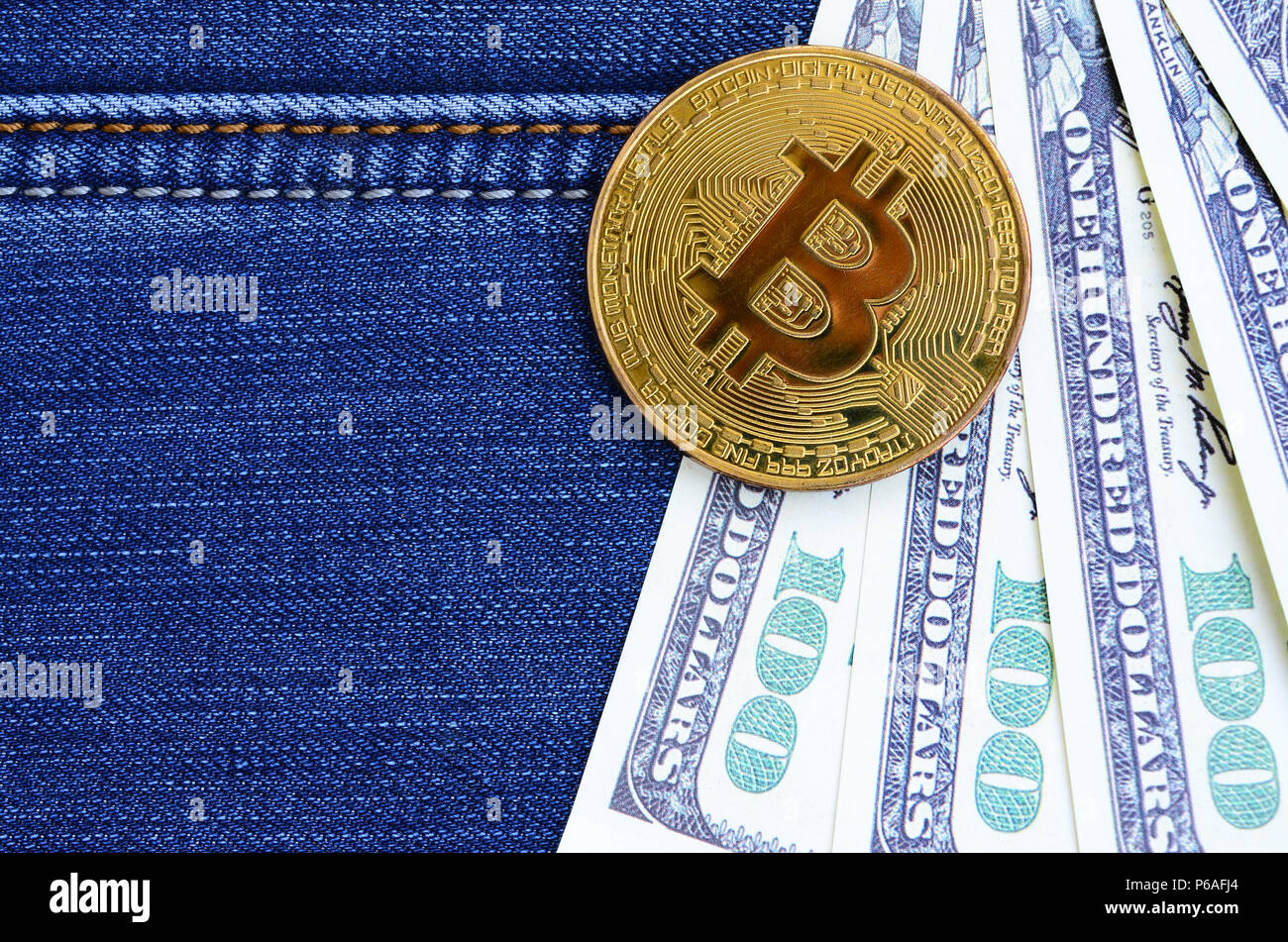 Golden Bitcoin and dollar bills lies on a blue jeans fabric. New virtual  money. New crypto currency in the form of the coins Stock Photo - Alamy