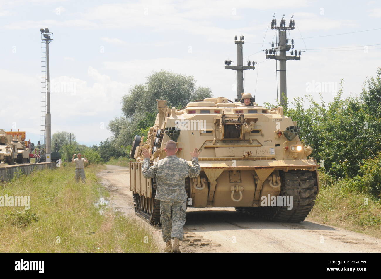 CINCU, Romania - A U.S. Soldier guides an M88 Hercules Recovery Vehicle as it backs-up along a dirt road in Viola, Romania July 5. The vehicle, belonging to the 116th Cavalry Brigade Combat Team (CBCT), Idaho Army National Guard is in Romania to be used during Exercise Saber Guardian 2016, which starts July 27. The 116th CBCT is one of the U.S. units participating in the exercise, which will also include forces from 11 different countries. Stock Photo