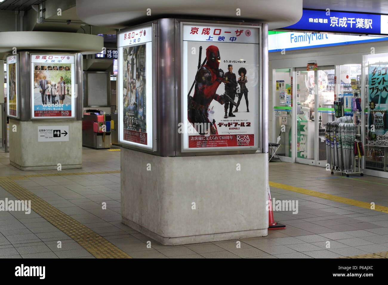 Chiba City Keisei line train station which has a Familymart convenience store and pillars carrying movie adverts including Deadpool 2. (6/2018) Stock Photo