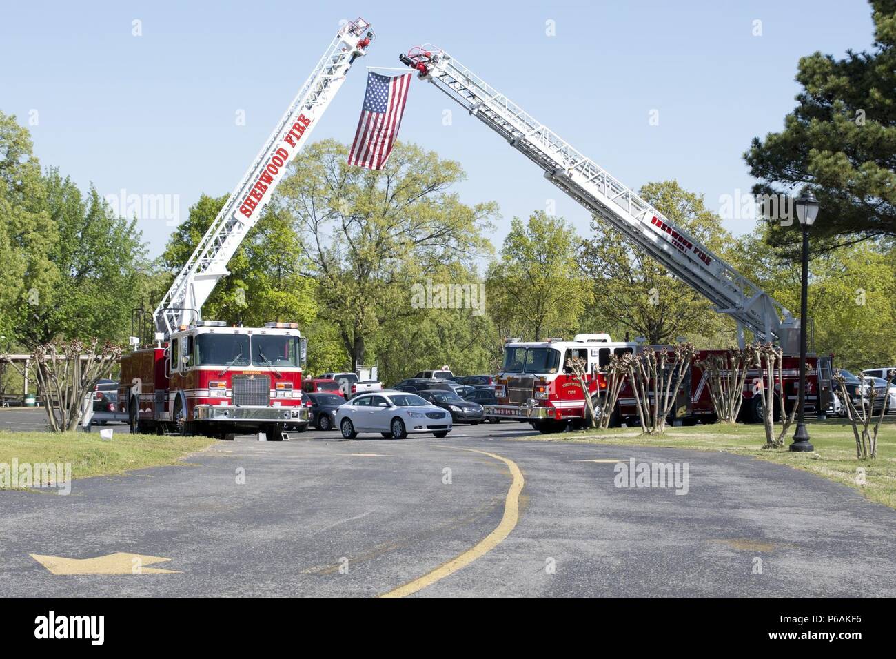 Sherwood Fire Department ladder trucks form a ladder arch for the 11th