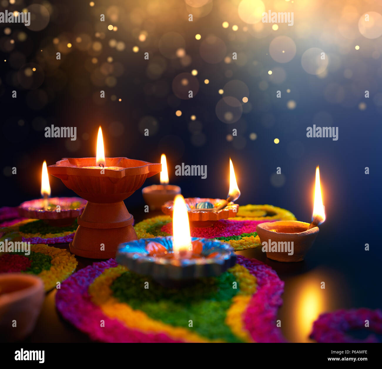 Diya lamps lit on colorful rangoli during diwali celebration Stock Photo -  Alamy