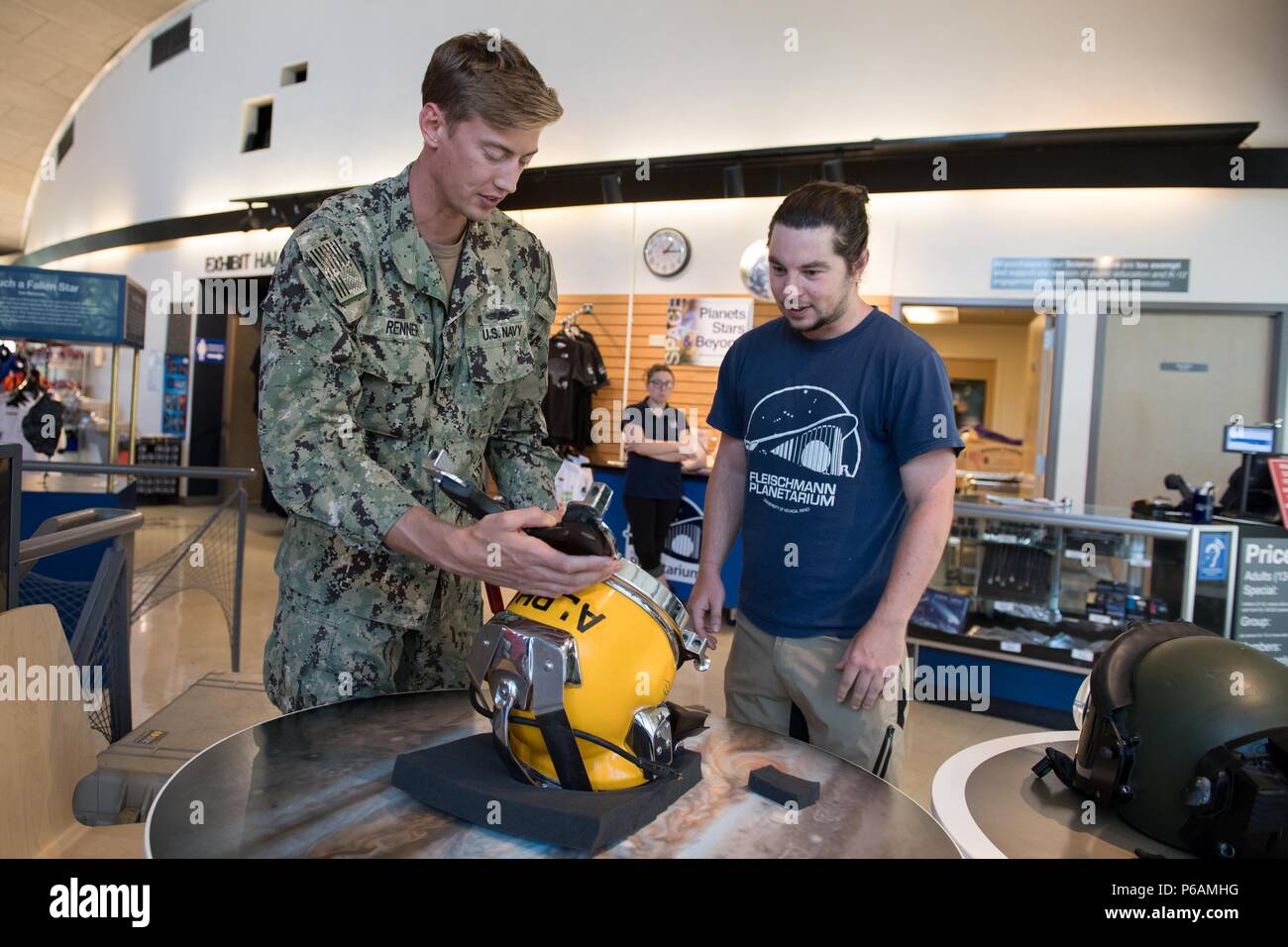 RENO, Nev. (June 22, 2018) Navy Diver 2nd Class Adam Renner, assigned to Southwest Regional Maintenance Center Alpha Dive Team, describes the KM-37 diving helmet to an employee at the Fleischmann Planetarium in support of Reno/Carson City Navy Week. The Navy Office of Community Outreach uses the Navy Week program to bring Navy Sailors, equipment and displays to approximately 15 American cities each year for a week-long schedule of outreach engagements. (U.S. Navy photo by Mass Communication Specialist 3rd Class Abigayle Lutz/Released) Stock Photo