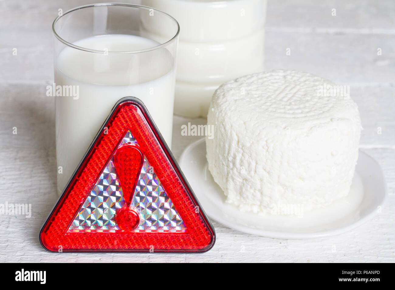 Lactose intolerance with milk dairy product and warning sign concept