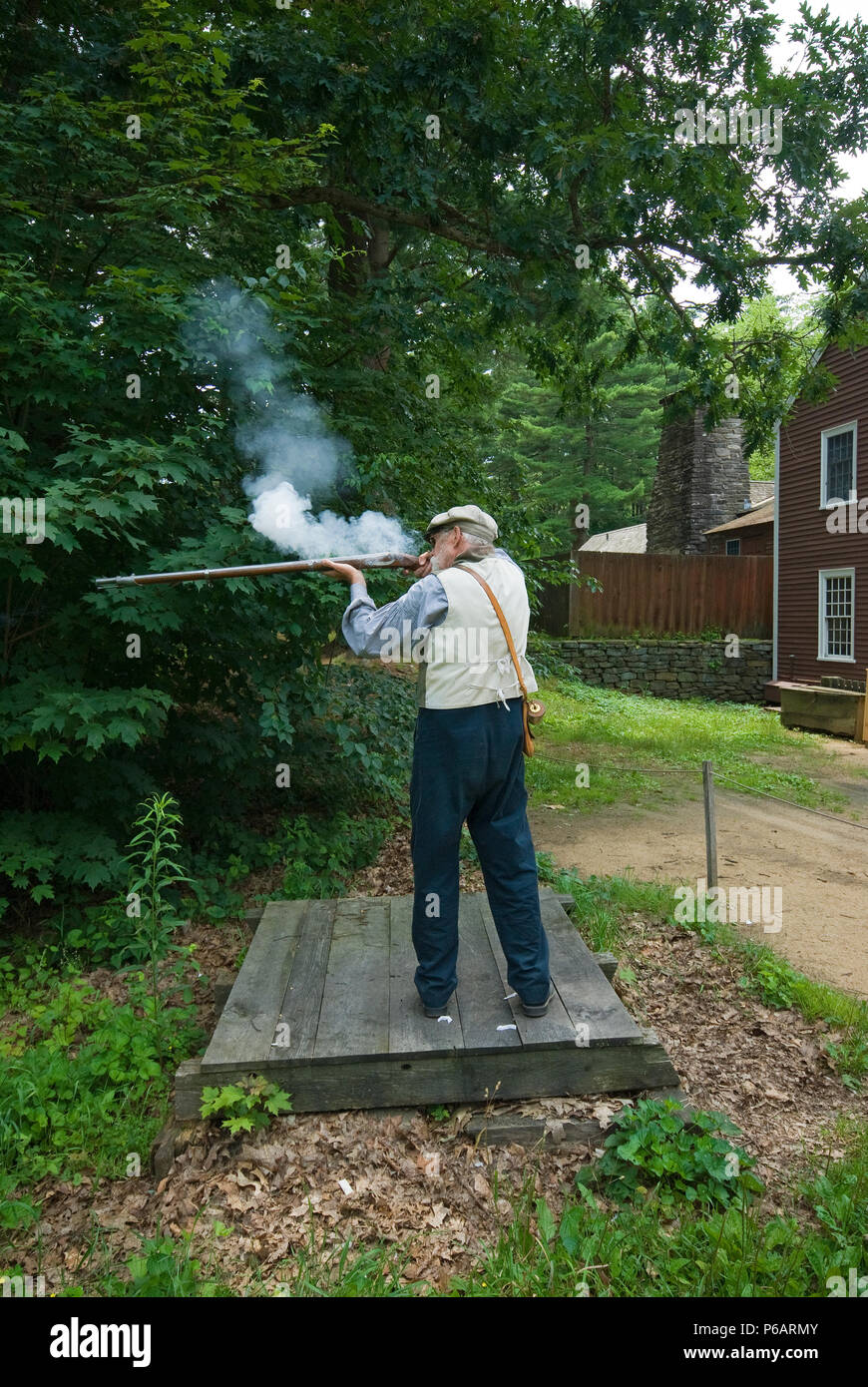 Old man with a flintlock rifle shooting for demonstration, Old Sturbridge Village, Sturbridge, Worcester County, Massachusetts, USA Stock Photo