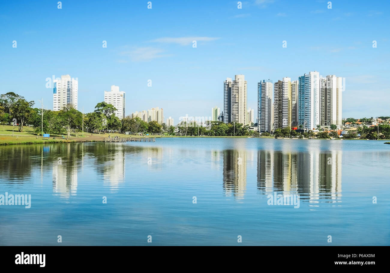 Lake of a urban park on a beautiful sunny day. The water of the lake with some buildings on the background and nature around. Photo at Campo Grande MS Stock Photo