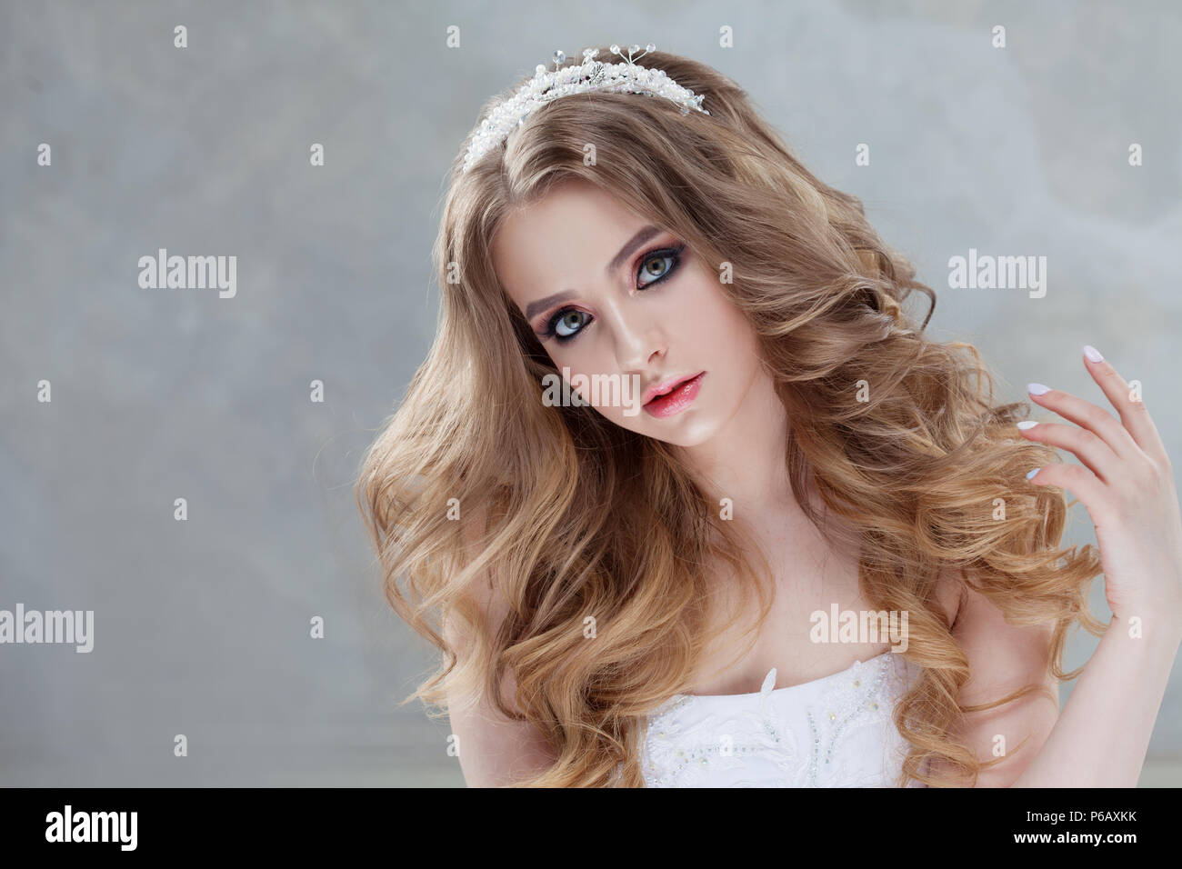 Young charming bride in wedding dress. Make-up and hairstyle with voluminous curls. Light gray textured background, free space Stock Photo - Alamy Young charming bride in wedding dress. Make-up and hairstyle with voluminous curls. Light gray textured background, free space Stock Photo - Alamy