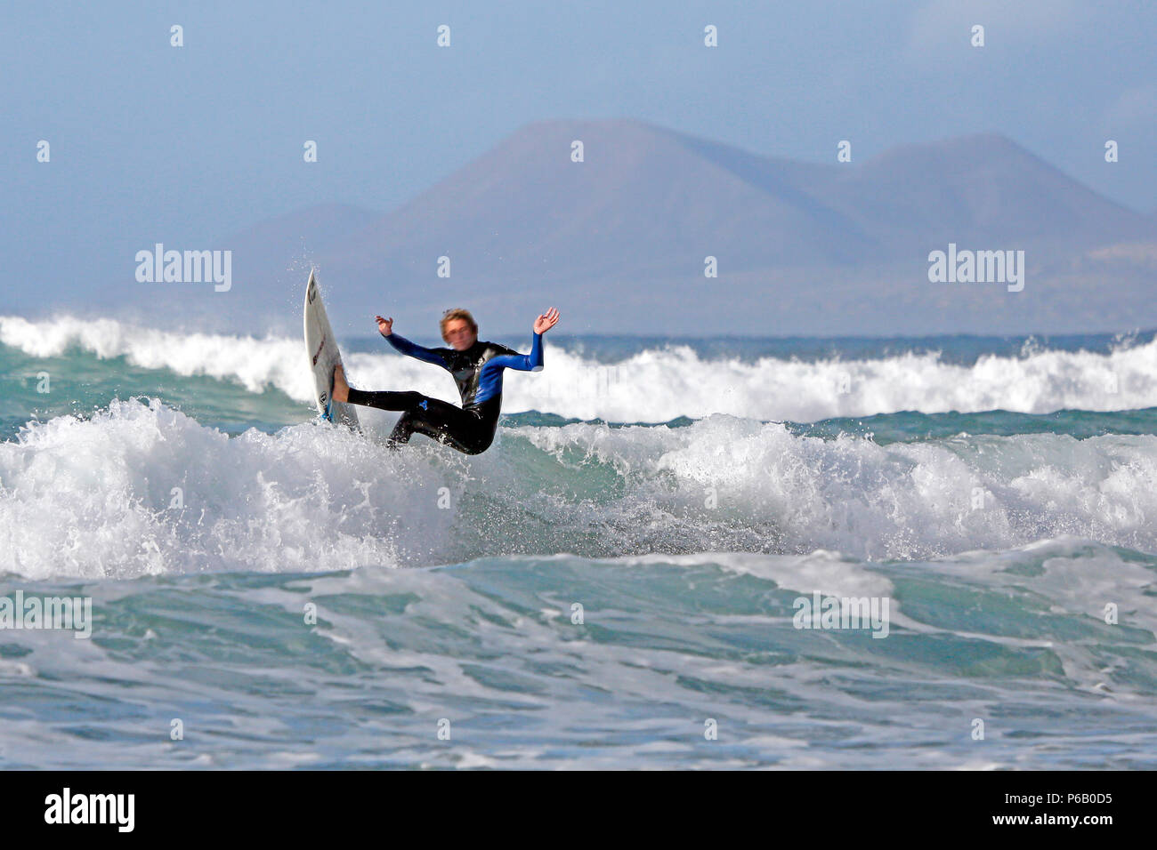 Spain. Canary Islands. Lanzarote. Famara. Playa Famara. Beach to surf.  Surfer in the waves Stock Photo - Alamy