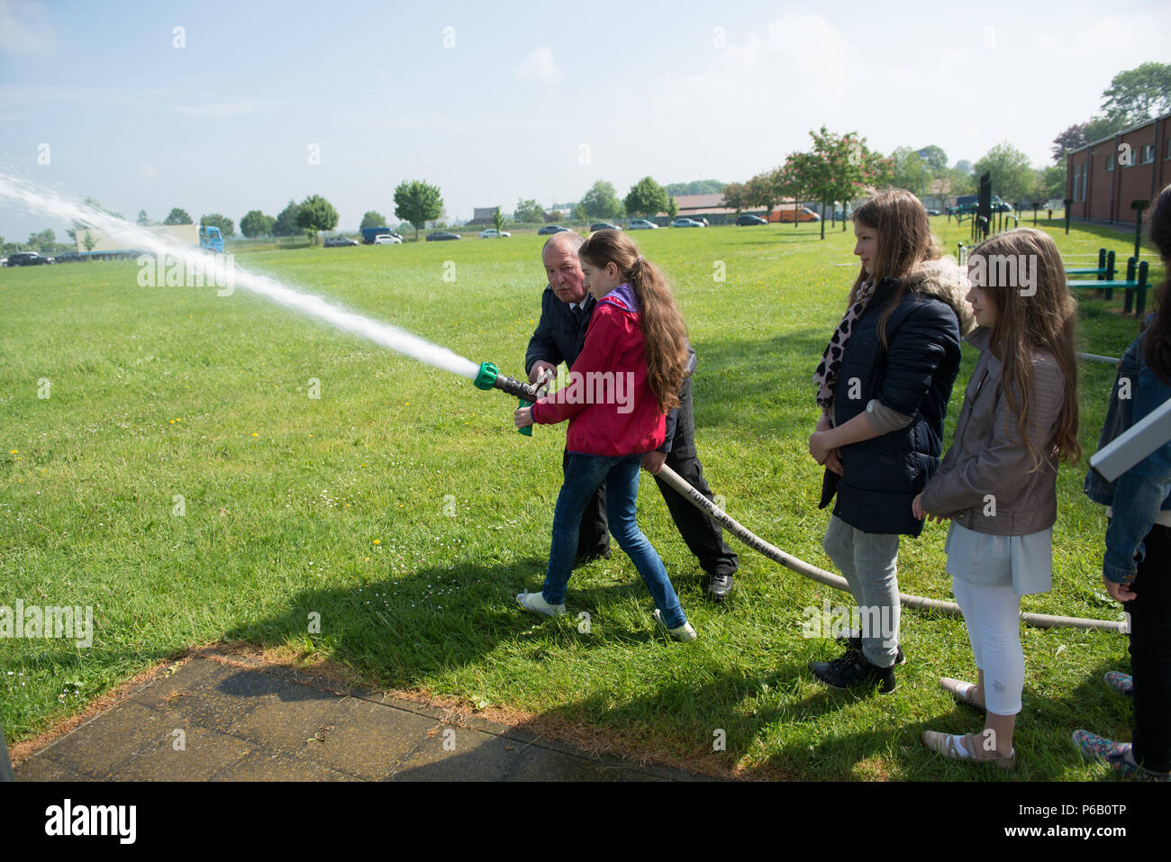 Belgian schoolchilds from the Lens elementary school stand in line to hold a fire hose during USAG Benelux safety day, on Chièvres Air Base, Chièvres, Belgium, May 26, 2016. (U.S. Army photo by Visual Information Specialist Pierre-Etienne Courtejoie/Released) Stock Photo