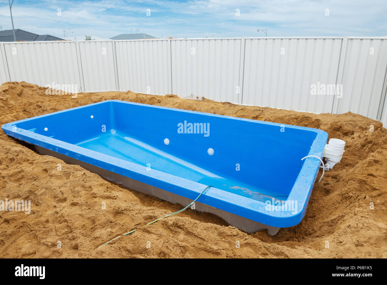 Swimming pool under construction.Installation plastic fiberglass pool in the ground at house backyard. Construction site Stock Photo