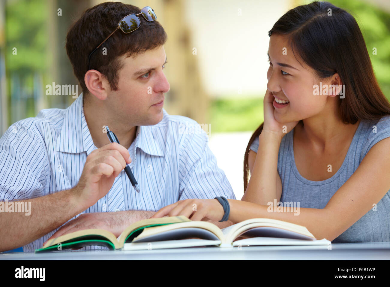 Caucasian male college students study together with asian female ...