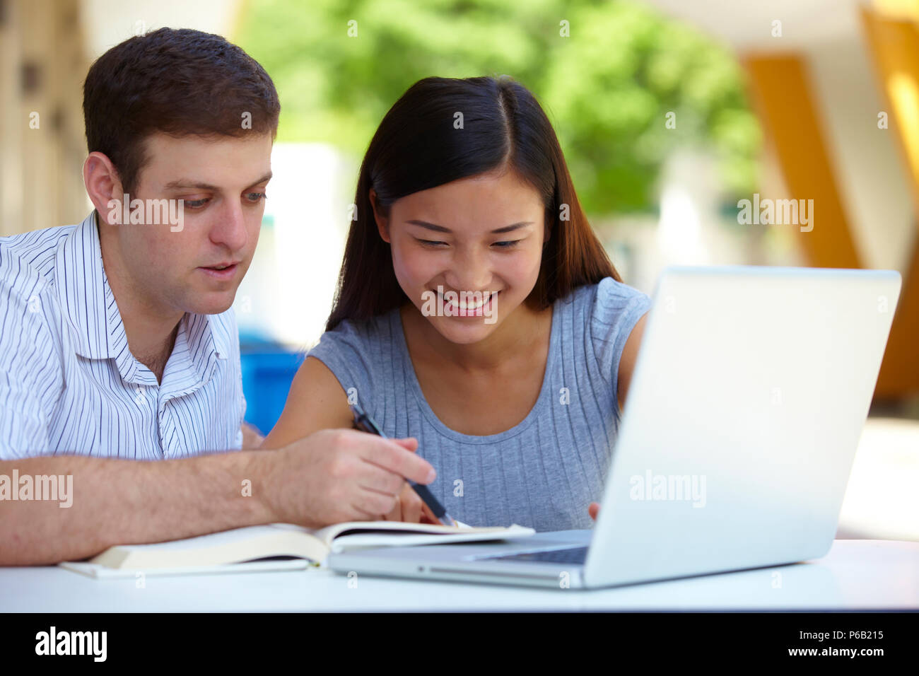 Caucasian male college students study together with asian female ...