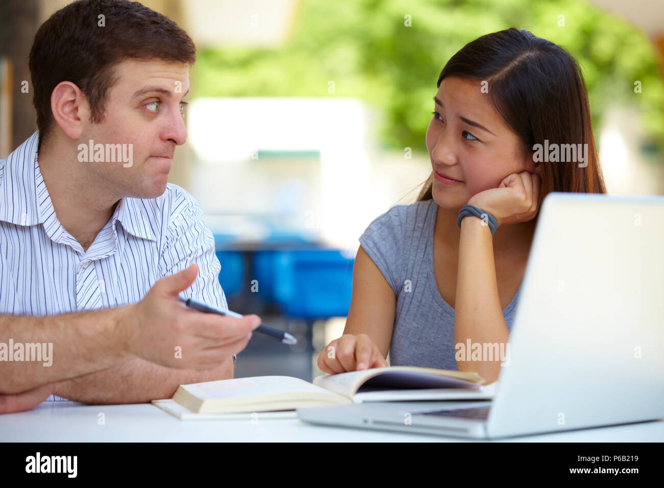 Caucasian male college students study together with asian female ...