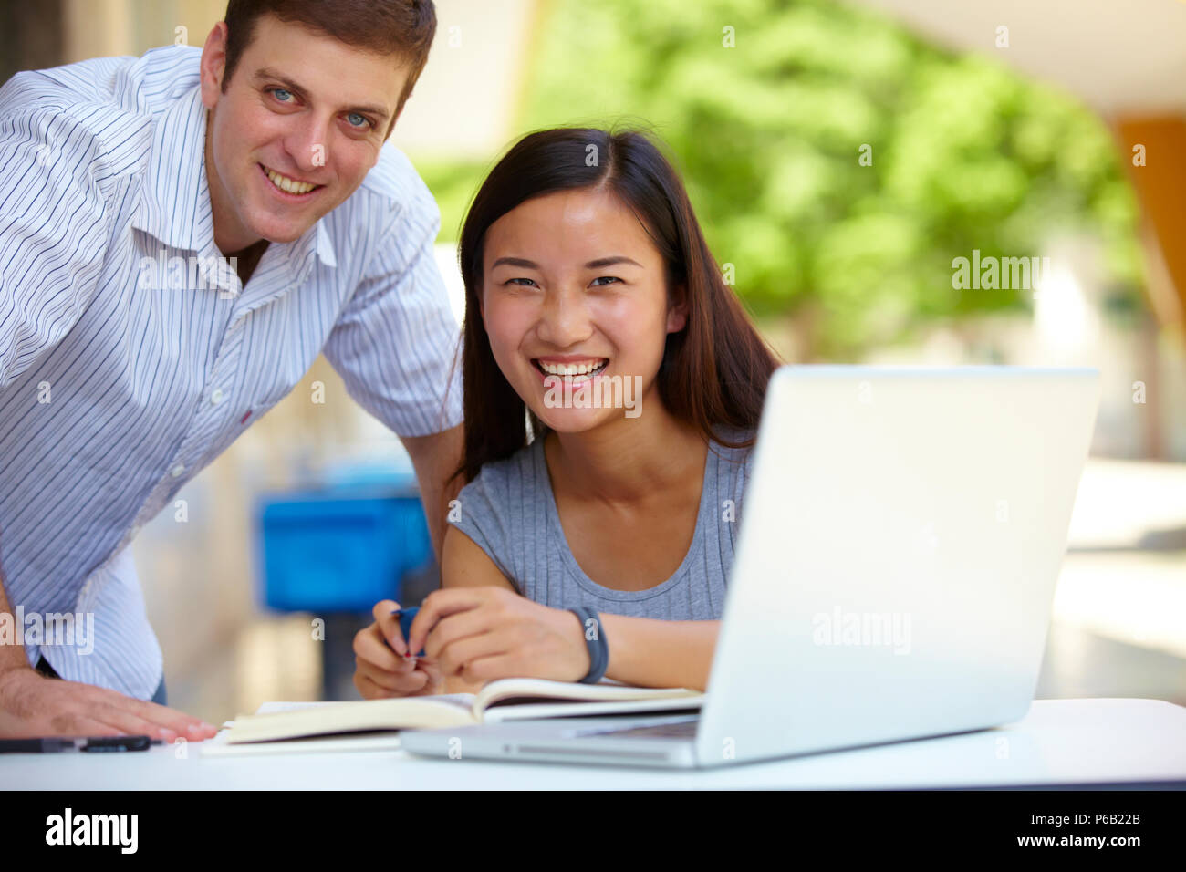 Caucasian male college students study together with asian female ...