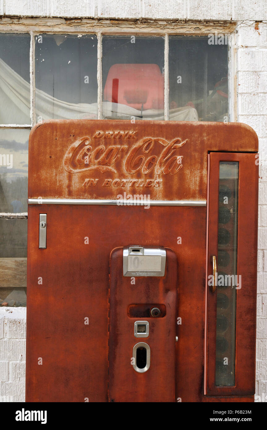 An antique Coca-Cola vending machine stands outside an old Phillips 66 gas station in the Route 66 town of Adrian, Texas. Stock Photo