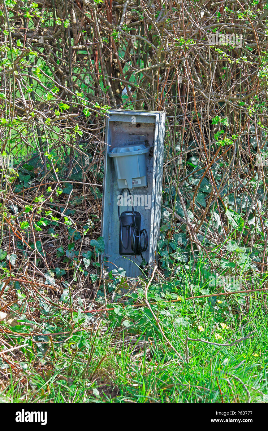 A roadside steel elecrticity supply cabinet adjacent to a fields gate containing a transformer and capacitor for an electric cattle control fence. Stock Photo